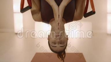 教练倒挂在<strong>室内吊床</strong>上。 做反重力瑜伽的女孩